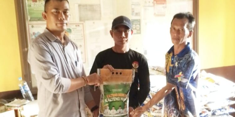 Camat Mantangai, Yubderi menyerahkan bantuan paket Bapok kepada warga.