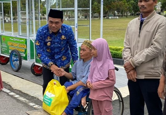 Wakil Wali Kota Palangka Raya, Achmad Zaini menyerahkan bantuan berupa gerobak dan paket bapok kepada warga penerima. (Foto: Istimewa)