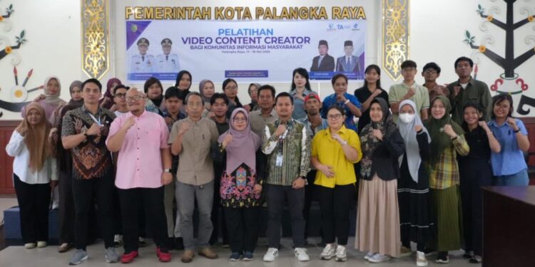 Sekretaris Diskominfo Palangka Raya, Normalasari, bersama masyarakat berfoto bersama di Aula Peteng Karuhei II.