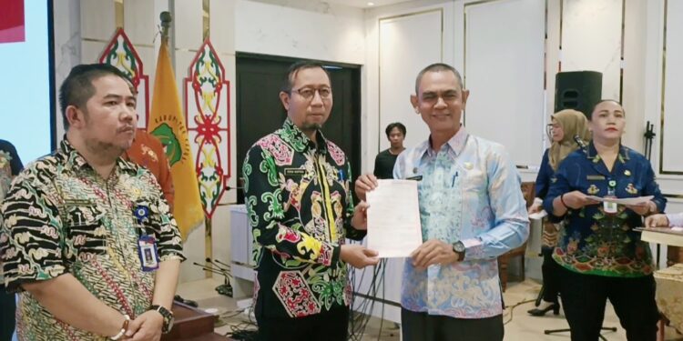 Asisten Perekonian dan Pembangunan Setda Kapuas, Vitrianson menyerahkan Penyerahan surat SPPT PBB-P2 Tahun 2025 kepada pejabat.