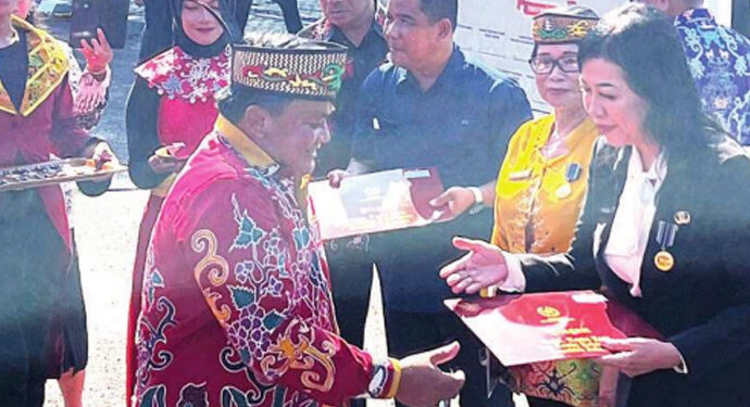 Ketua DPRD Kapuas Ardiansah menyerahkan lencana dalam rangka peringatan Hardiknas dan Hari Otda, di halaman Kantor Bupati Kapuas, Kamis (8/5).